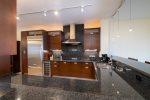 Gorgeous dark cabinetry highlighted with stainless appliances and granite counters